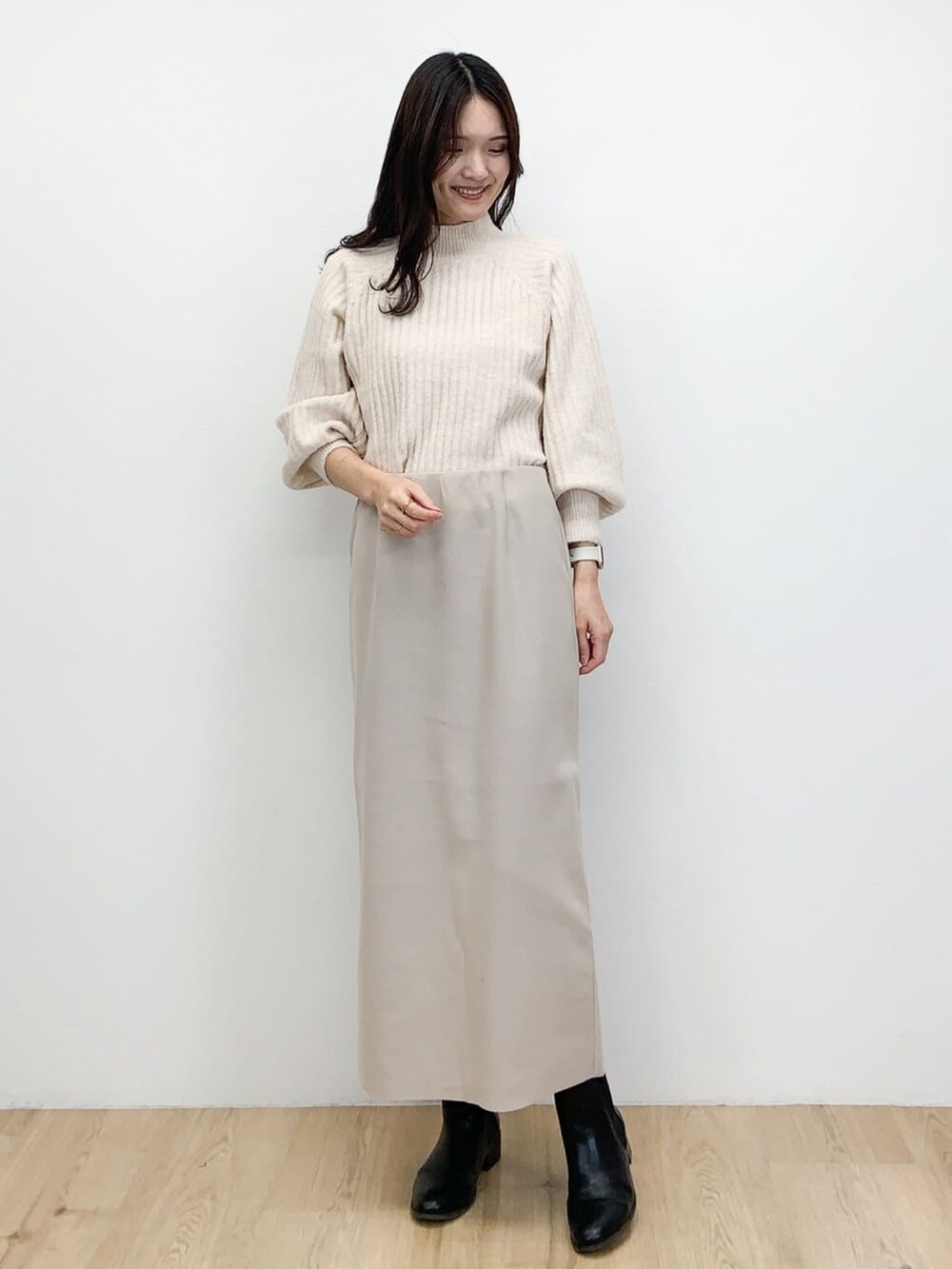 ブラウン系のピーコート、ベージュ系のスカート、ホワイト系のニット/セーターを着用したレディースの冬コーディネートの4枚目の写真