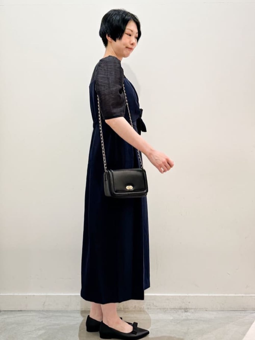 ブラック系のショルダーバッグ、ブラック系のその他シューズ、ブルー系のワンピースを着用したレディースの秋コーディネートの2枚目の写真