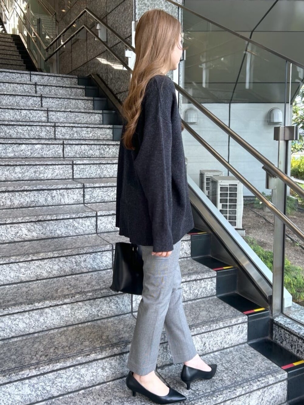 グレー系のニット/セーター、ブラック系のその他パンツ、ブラック系のトートバッグを着用したレディースの冬コーディネートの3枚目の写真