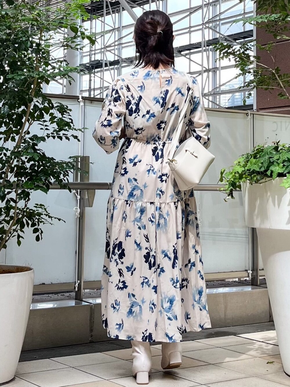 ベージュ系のワンピース、ホワイト系のショルダーバッグ、ホワイト系のブーツを着用したレディースの秋コーディネートの3枚目の写真