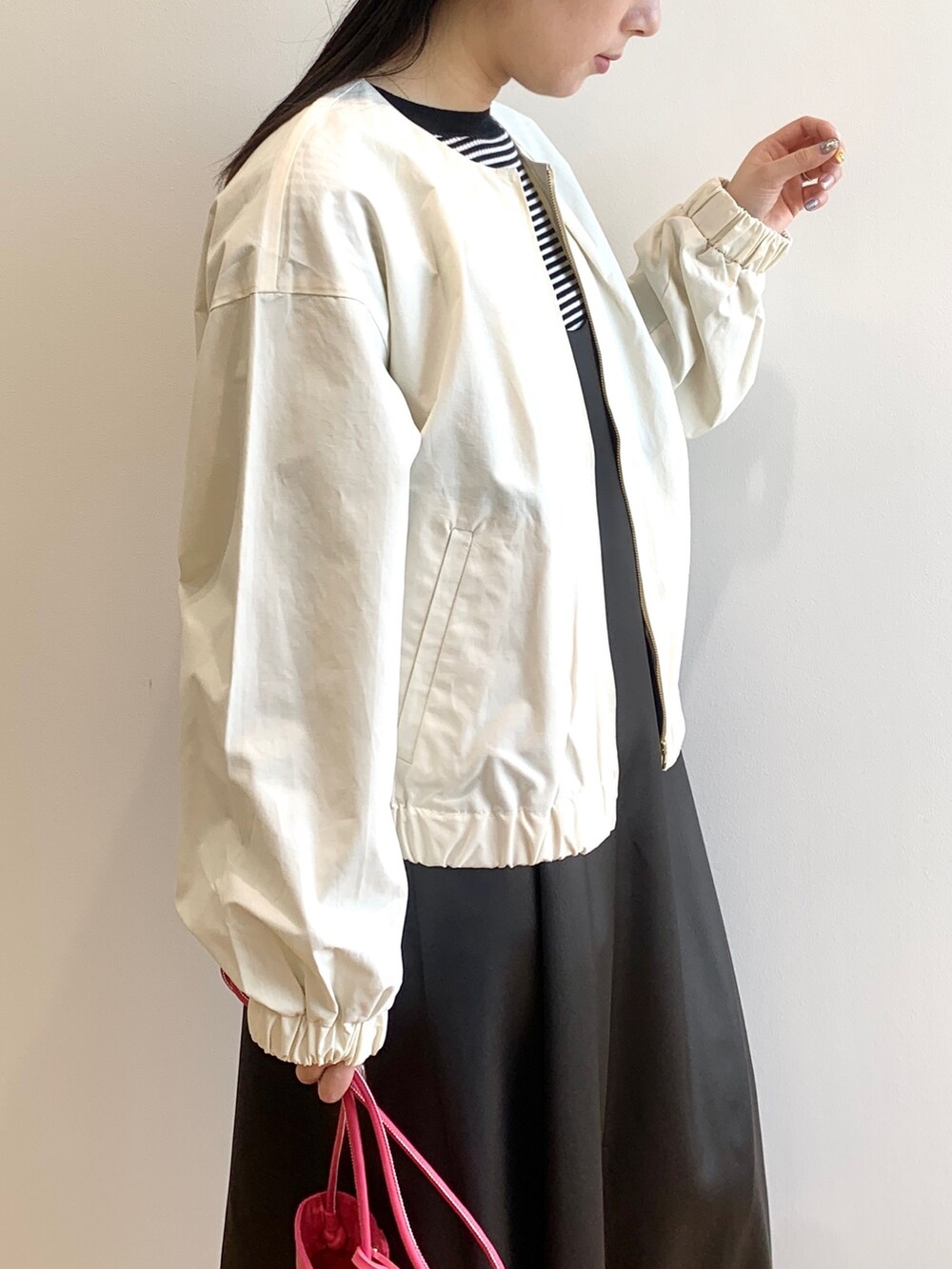 ホワイト系のニット/セーター、ホワイト系のブルゾン、グレー系のワンピースを着用したレディースの春コーディネートの4枚目の写真