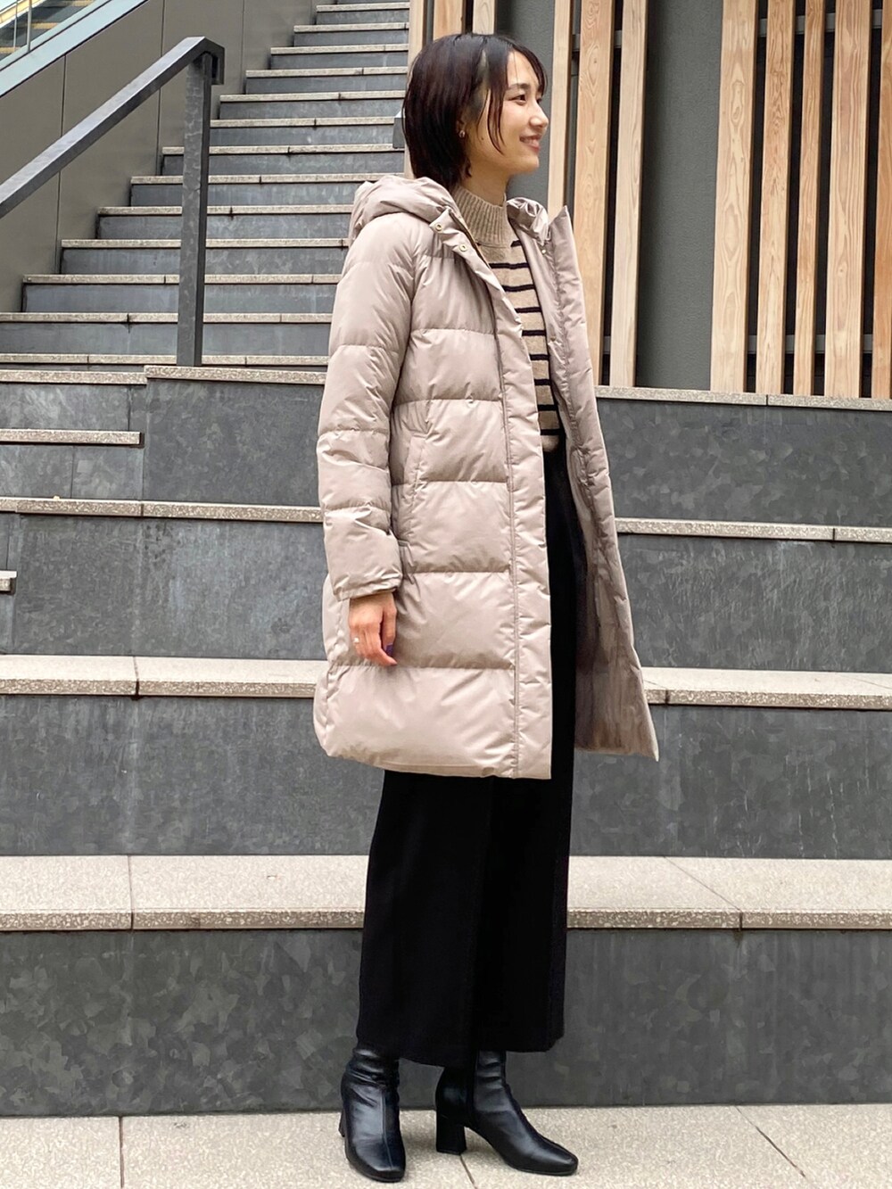 ブラック系のその他パンツ、ベージュ系のニット/セーター、ブラック系のブーツを着用したレディースの冬コーディネートの2枚目の写真