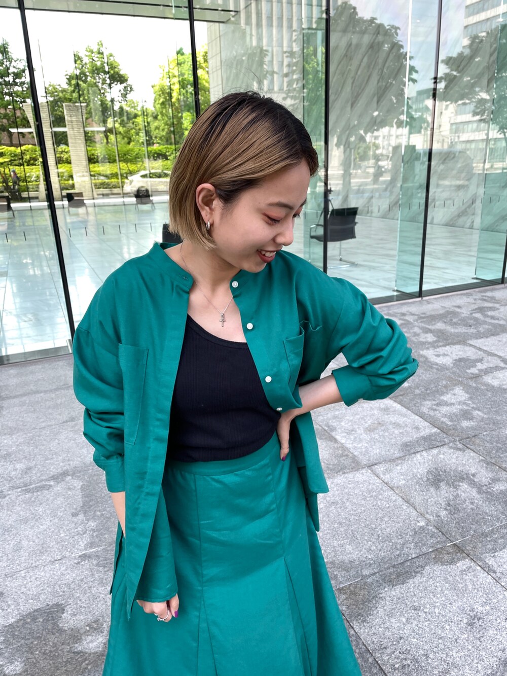 グリーン系のシャツ/ブラウス、グリーン系のスカート、ベージュ系のトートバッグを着用したレディースの春コーディネートの2枚目の写真