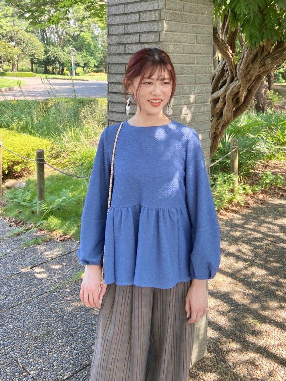 ブルー系のシャツ/ブラウス、シルバー系のパンプス、ブラウン系のその他パンツを着用したレディースの秋コーディネートの5枚目の写真