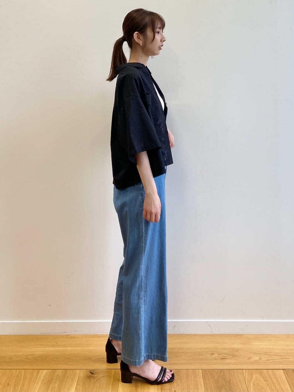 ブルー系のデニムパンツ、ブラック系のサンダル、ブラック系のシャツ/ブラウスを着用したレディースの夏コーディネートの3枚目の写真