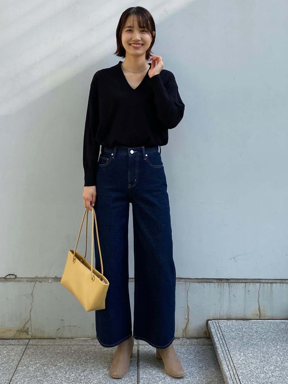 グレー系のノーカラーコート、ブルー系のその他パンツ、ブルー系のニット/セーターを着用したレディースの秋コーディネートの4枚目の写真