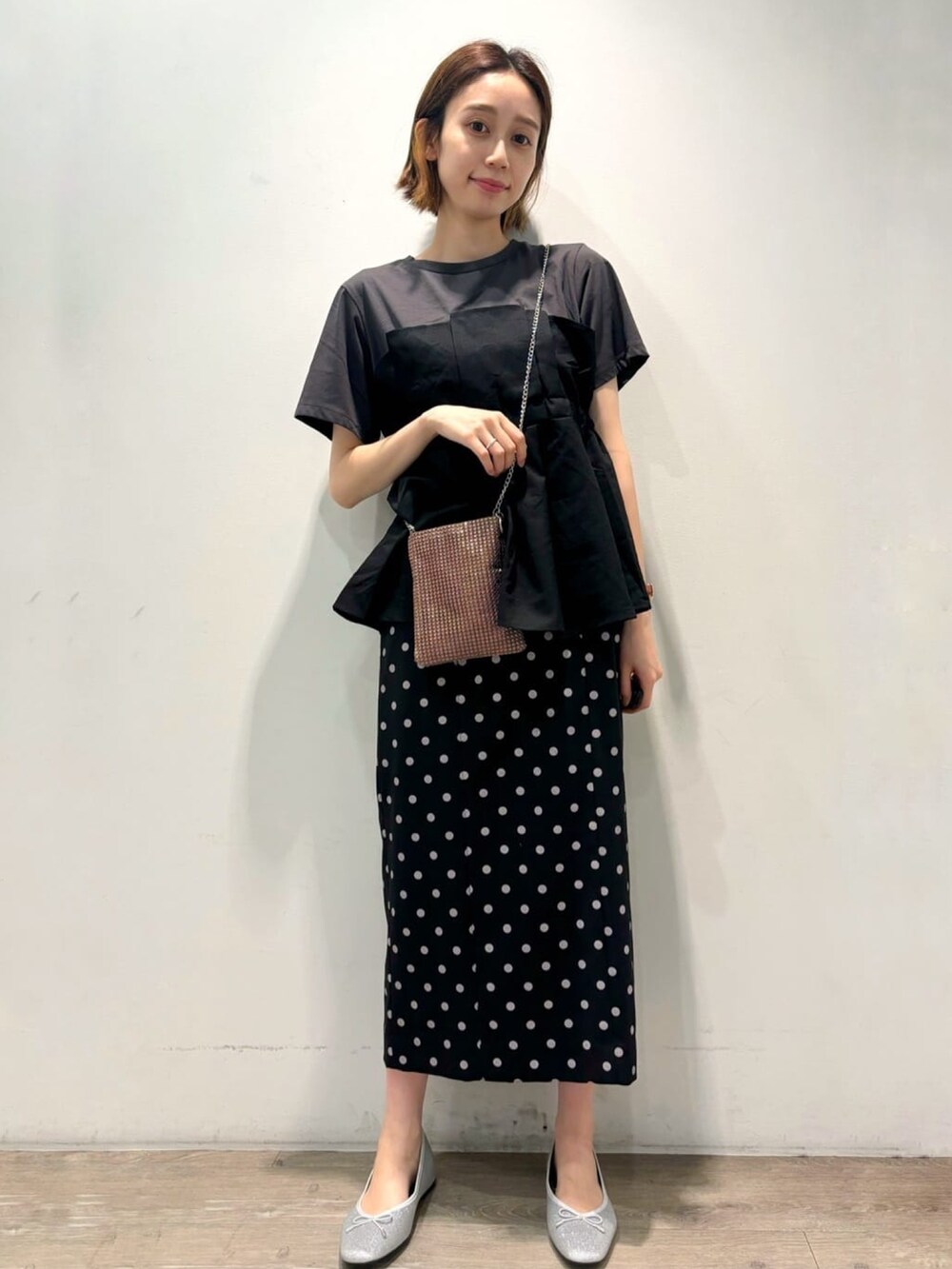 ブラック系のTシャツ/カットソー、シルバー系のパンプス、ブラック系のスカートを着用したレディースの夏コーディネートの5枚目の写真