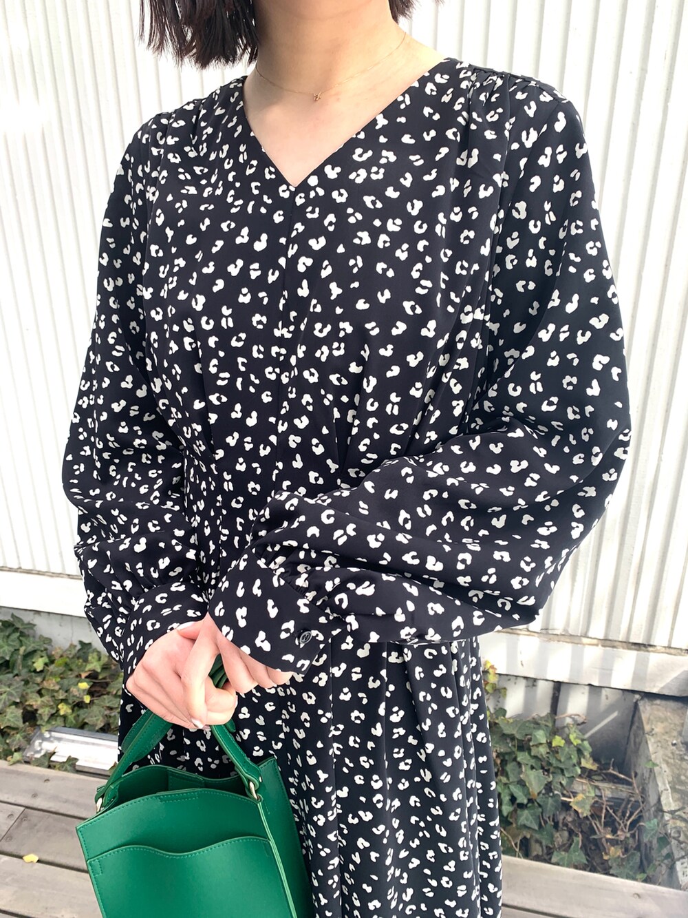 ブラック系のワンピース、ブラック系のその他シューズ、グリーン系のショルダーバッグを着用したレディースの冬コーディネートの2枚目の写真