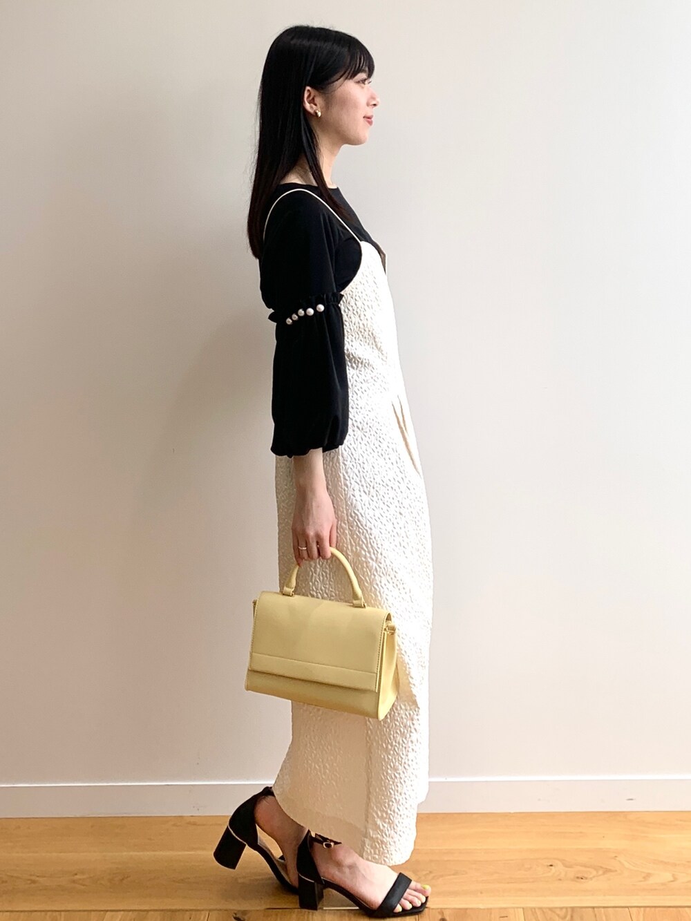 ホワイト系のワンピース、ブラック系のシャツ/ブラウス、イエロー系のショルダーバッグを着用したレディースの春コーディネートの2枚目の写真