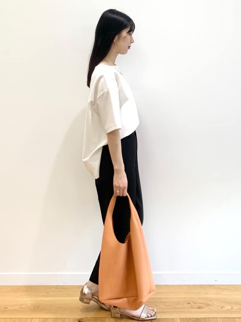 ホワイト系のTシャツ/カットソー、ブラック系のその他パンツ、オレンジ系のショルダーバッグを着用したレディースの夏コーディネートの2枚目の写真