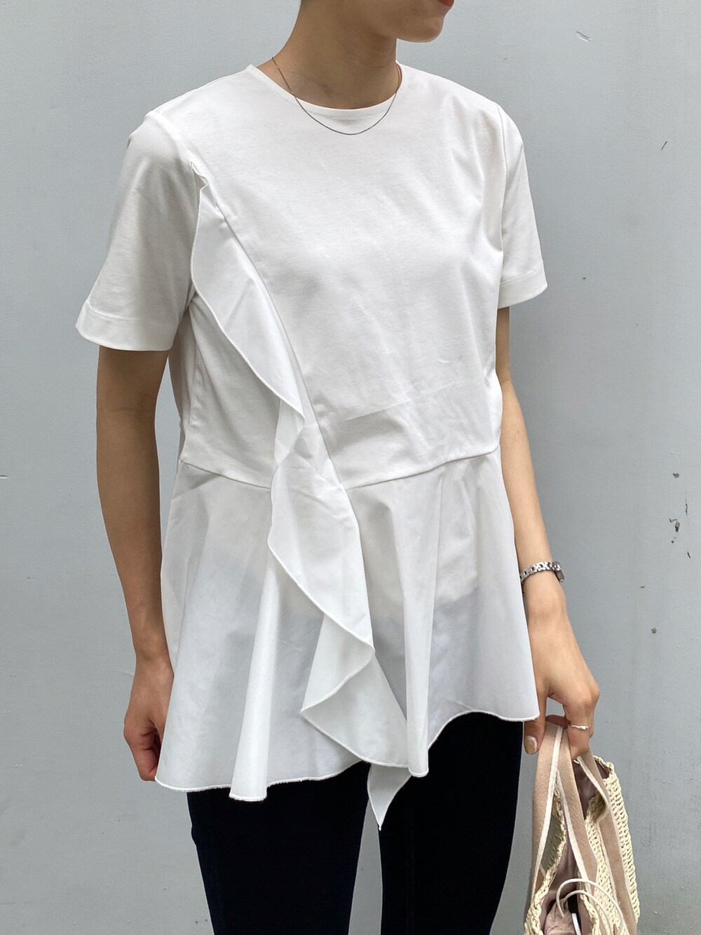ホワイト系のTシャツ/カットソー、ブルー系のデニムパンツ、ベージュ系のトートバッグを着用したレディースの夏コーディネートの3枚目の写真