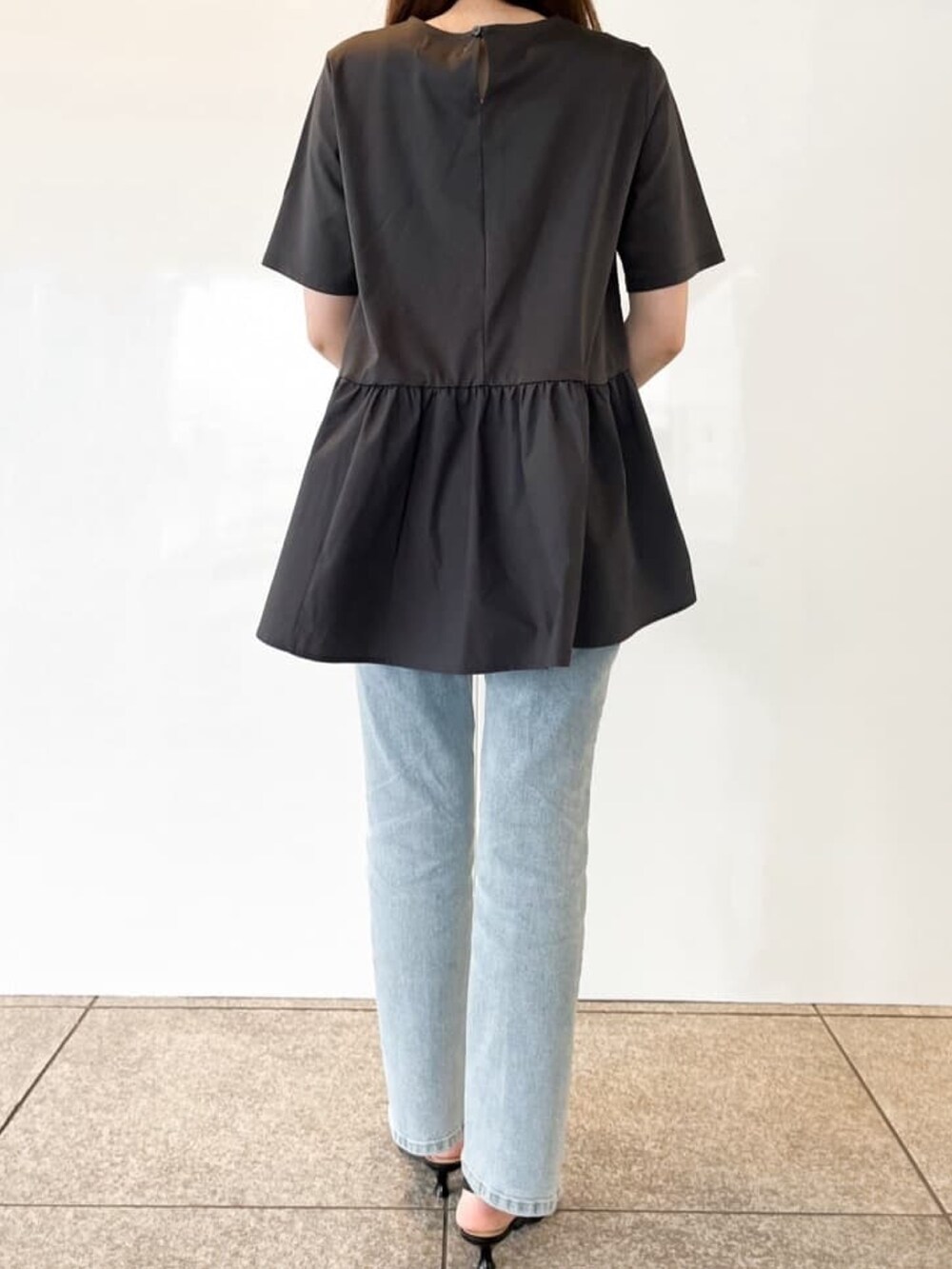 グレー系のTシャツ/カットソー、ブルー系のデニムパンツ、ブラック系のパンプスを着用したレディースの春コーディネートの5枚目の写真