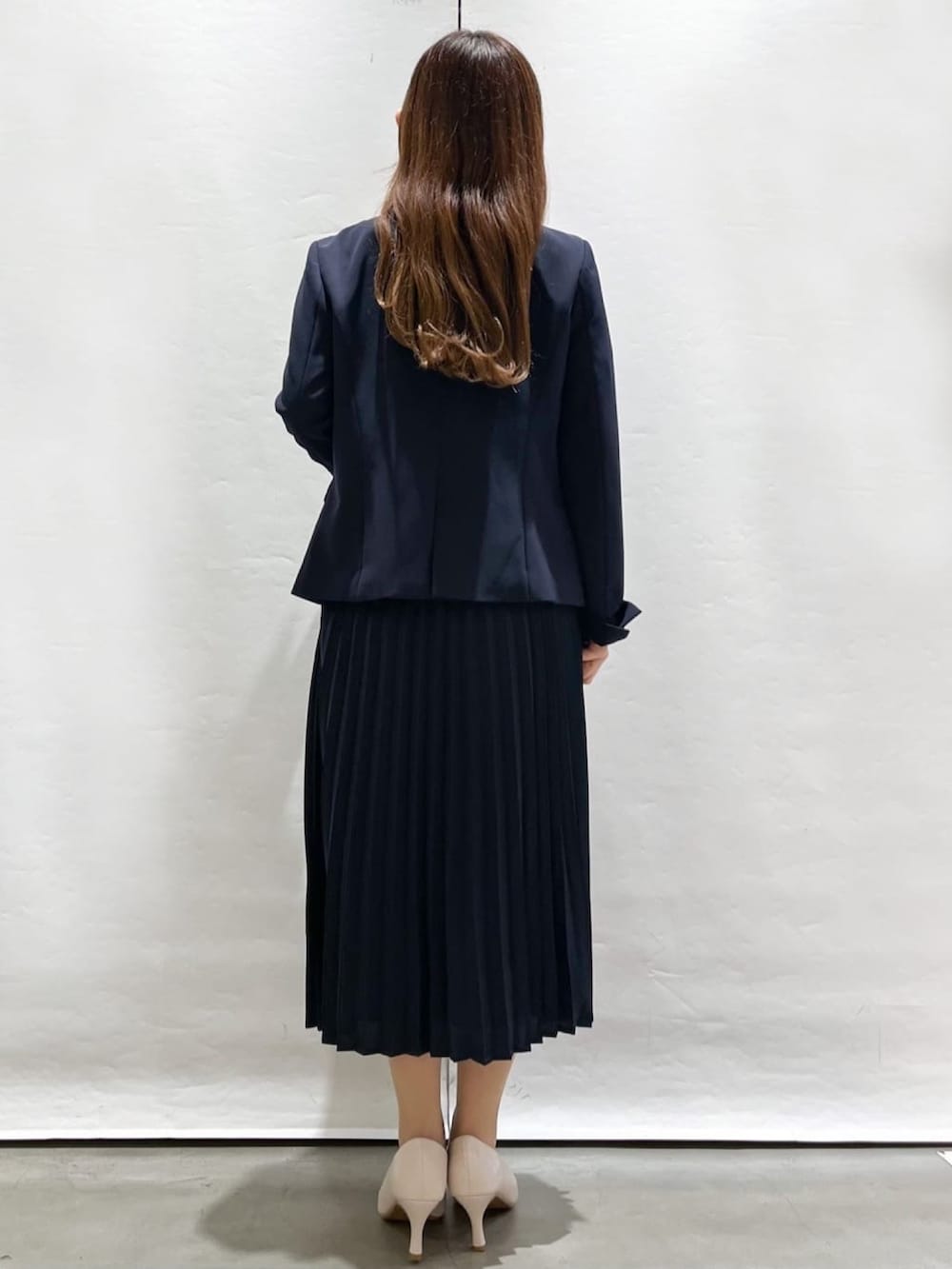 ブルー系のノーカラージャケット、ブルー系のワンピース、ホワイト系のパンプスを着用したレディースの春コーディネートの3枚目の写真