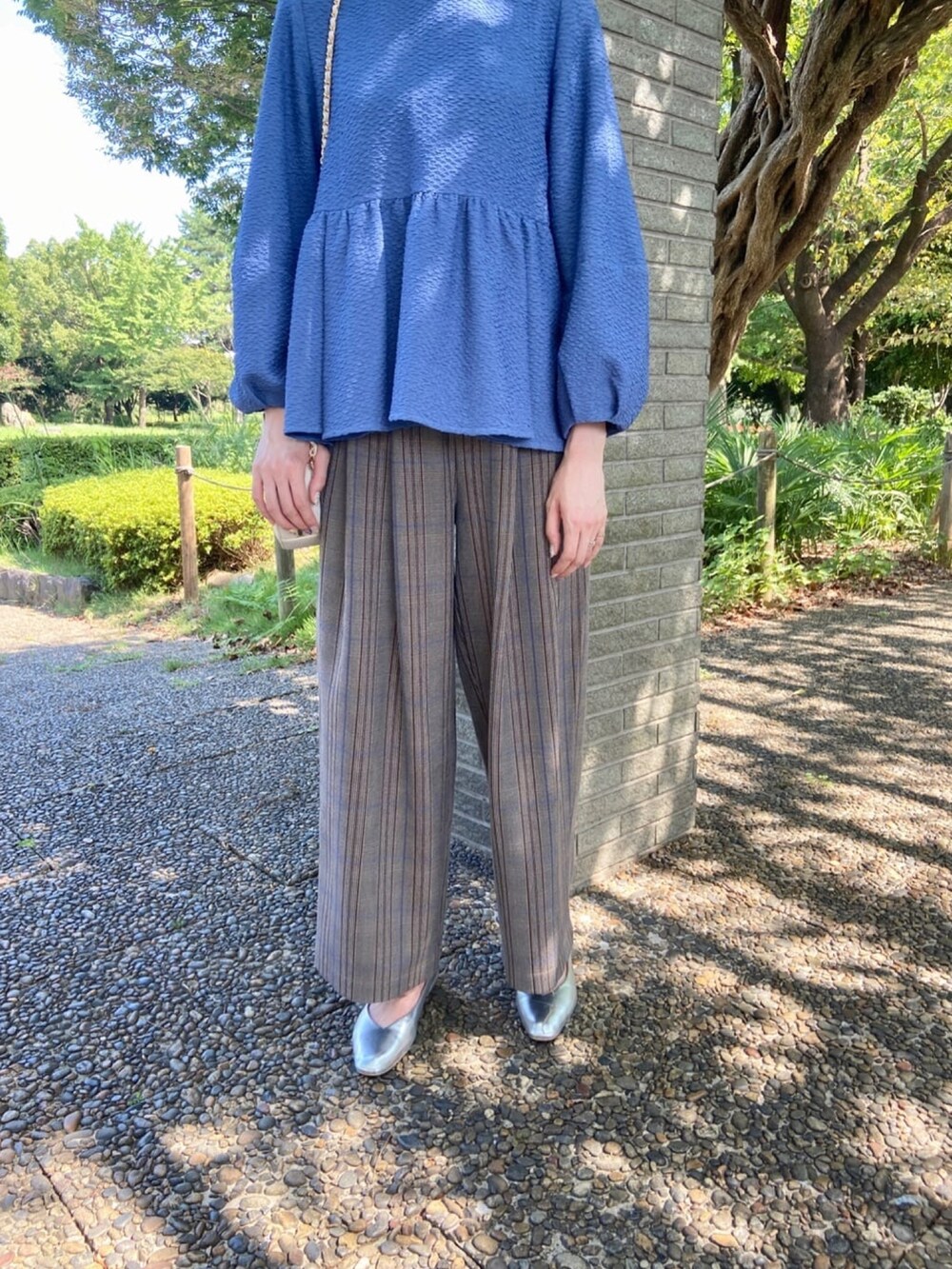 ブルー系のシャツ/ブラウス、シルバー系のパンプス、ブラウン系のその他パンツを着用したレディースの秋コーディネートの6枚目の写真