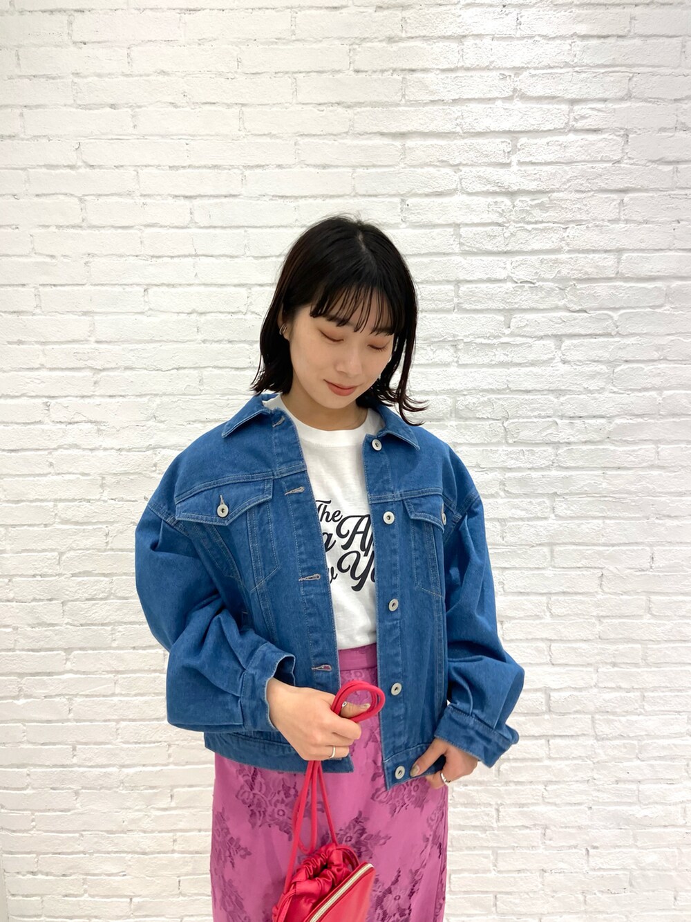 ホワイト系のTシャツ/カットソー、ブルー系のデニムジャケット、ピンク系のスカートを着用したレディースの春コーディネートの2枚目の写真