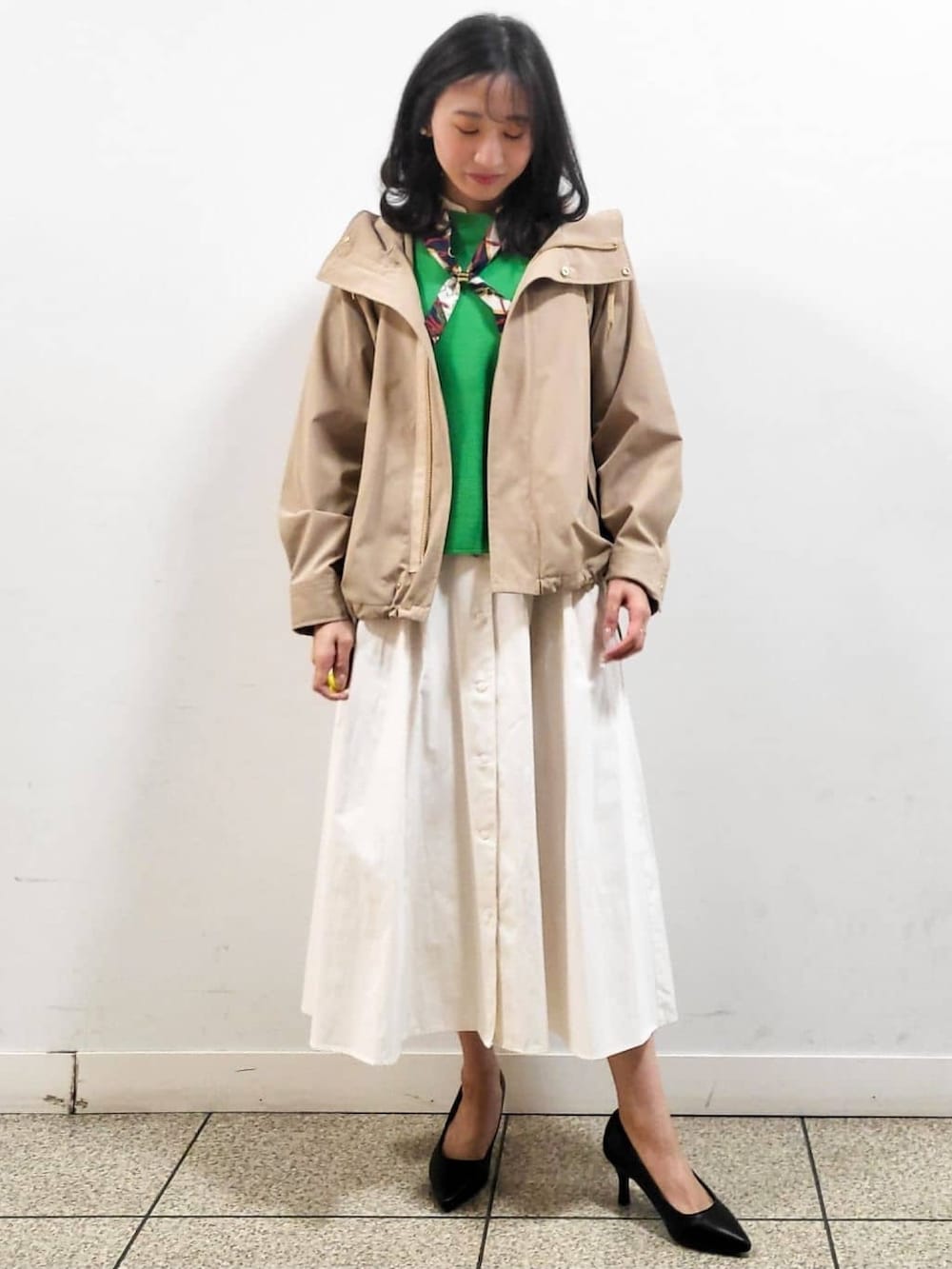 ホワイト系のワンピース、ブラック系のパンプス、ベージュ系のブルゾンを着用したレディースの春コーディネートの2枚目の写真