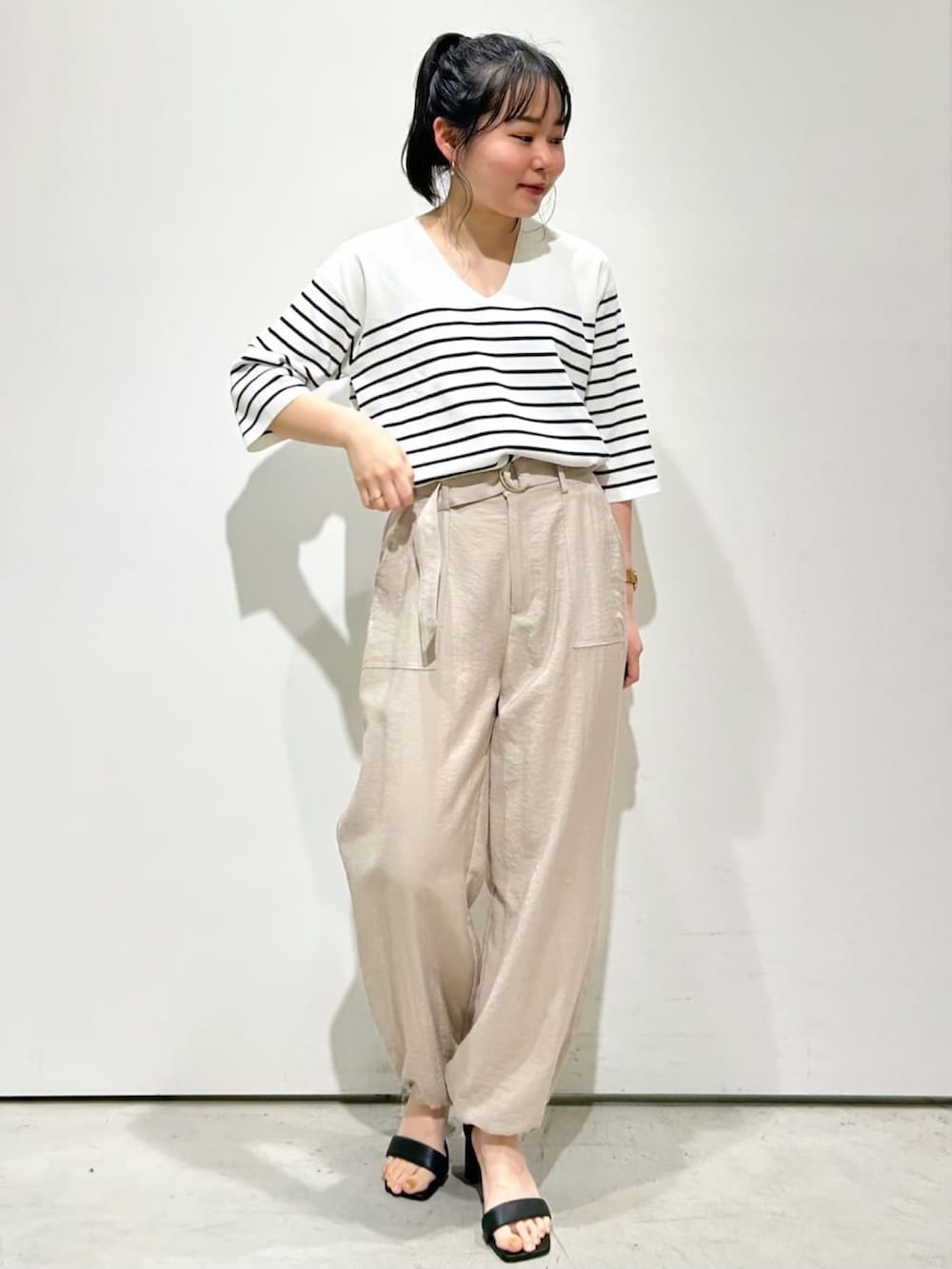 ベージュ系のその他パンツ、ブラック系のサンダル、ホワイト系のニット/セーターを着用したレディースの春コーディネートの3枚目の写真