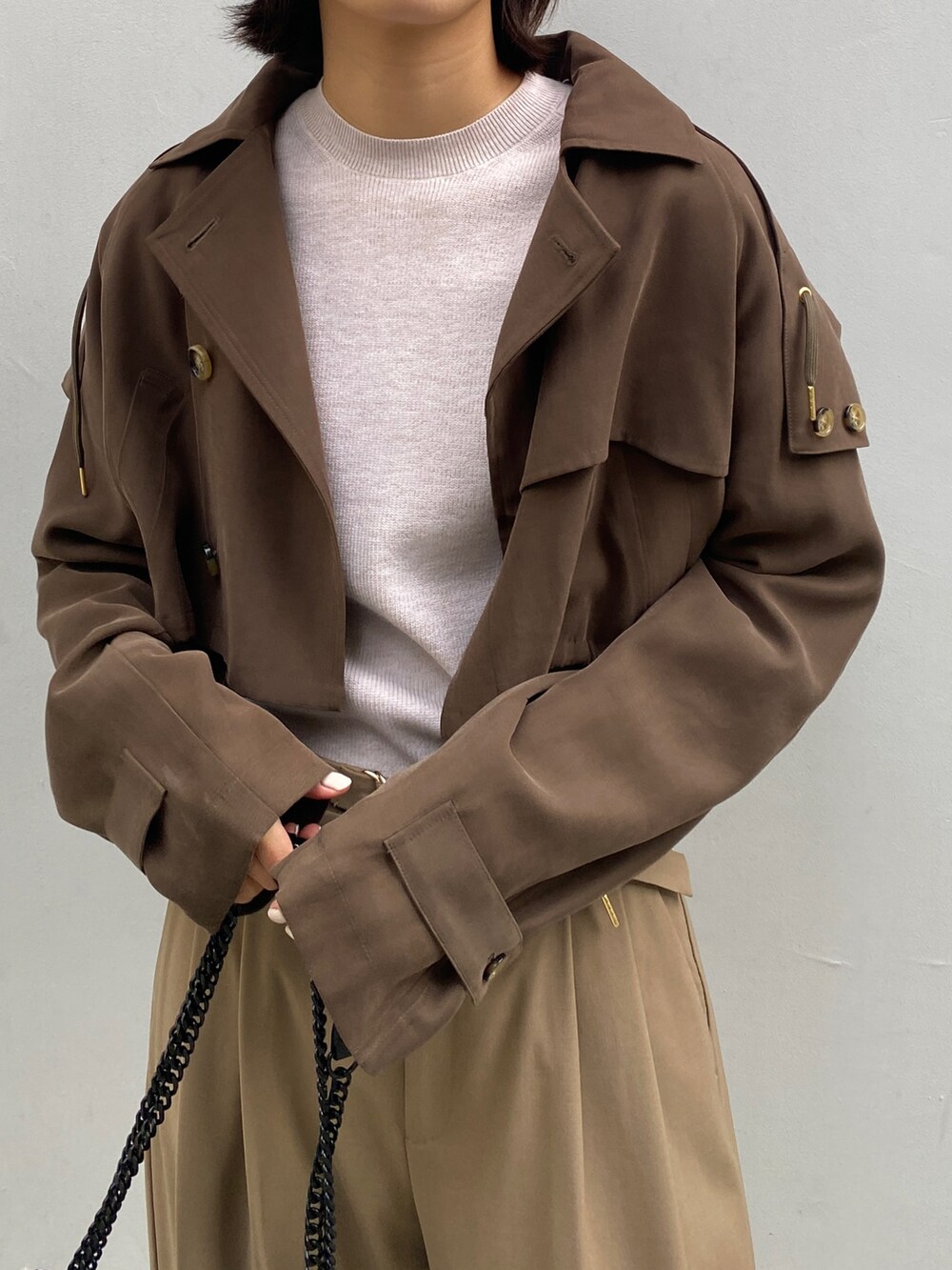 グリーン系のトレンチコート、ベージュ系のその他パンツ、ブラック系のショルダーバッグを着用したレディースの秋コーディネートの4枚目の写真