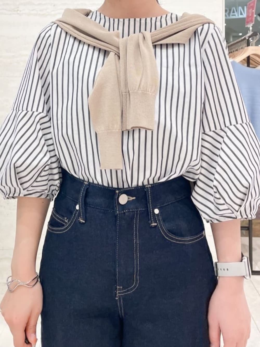 ブラック系のサンダル、ホワイト系のシャツ/ブラウス、ベージュ系のカーディガン/ボレロを着用したレディースの春コーディネートの2枚目の写真