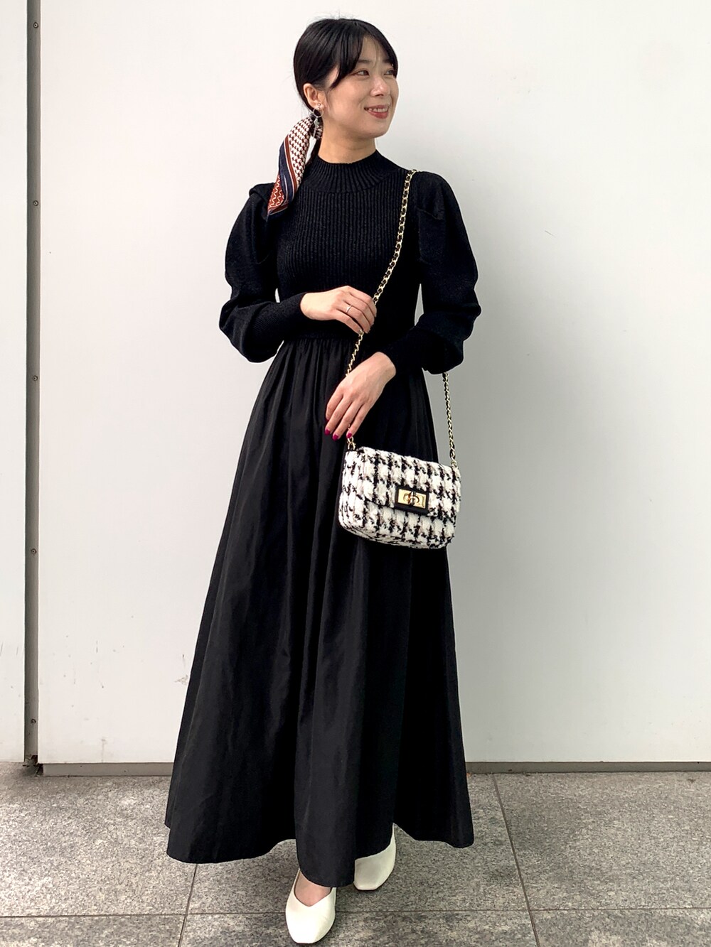 グレー系のテーラードジャケット、ブラック系のワンピース、ブラック系のショルダーバッグを着用したレディースの秋コーディネートの3枚目の写真