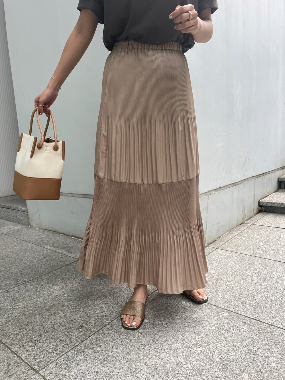 ブラウン系のTシャツ/カットソー、イエロー系のスカート、イエロー系のトートバッグを着用したレディースの春コーディネートの5枚目の写真