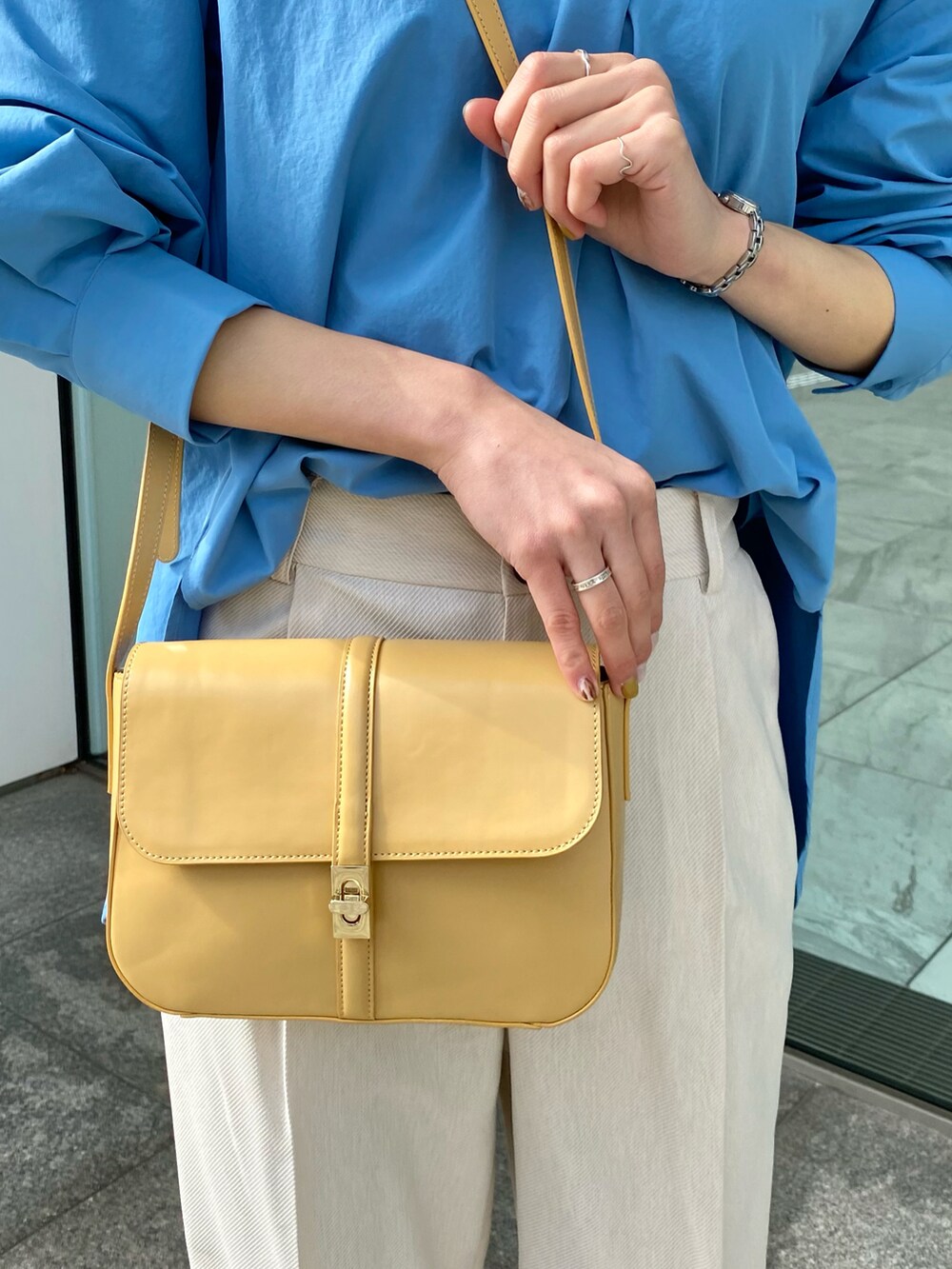 ブルー系のシャツ/ブラウス、イエロー系のショルダーバッグ、グレー系のその他パンツを着用したレディースの冬コーディネートの3枚目の写真