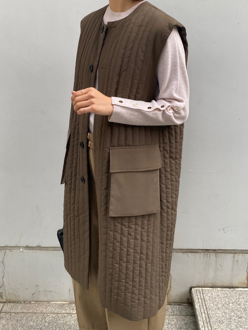 グリーン系のトレンチコート、ベージュ系のその他パンツ、ブラック系のショルダーバッグを着用したレディースの秋コーディネートの3枚目の写真