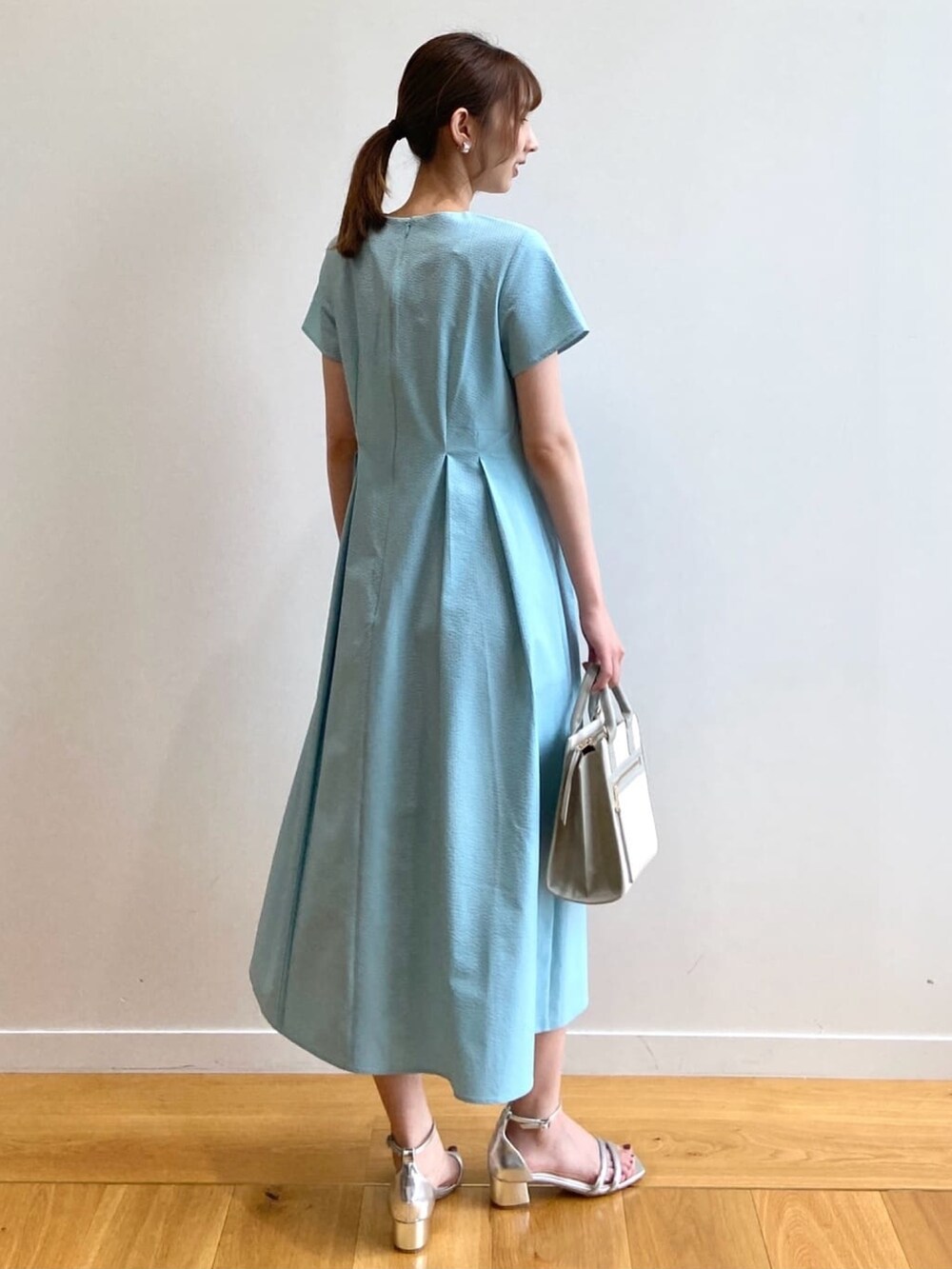ブルー系のワンピース、シルバー系のサンダル、グレー系のハンドバッグを着用したレディースの夏コーディネートの4枚目の写真
