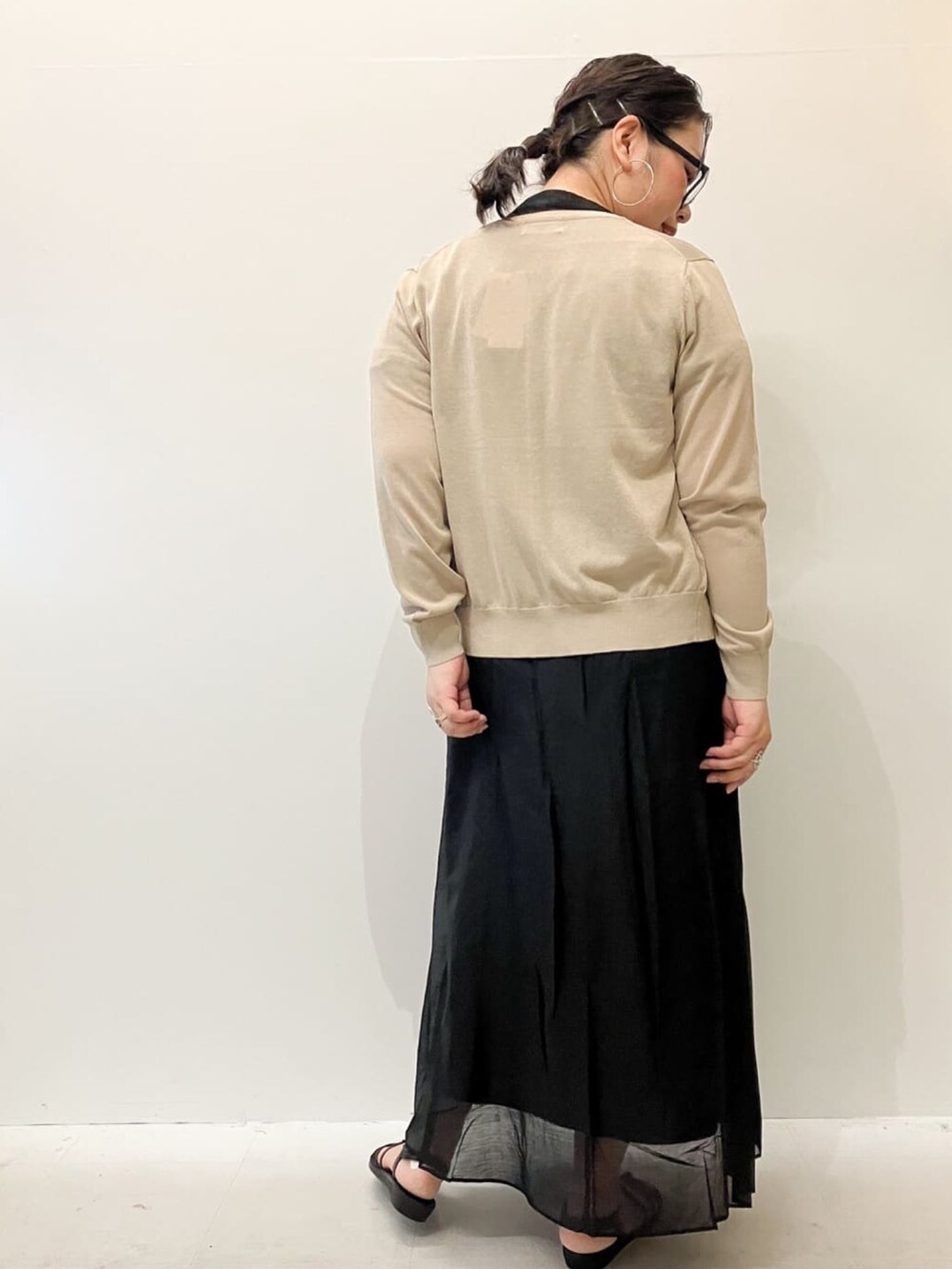 ベージュ系のカーディガン/ボレロ、ブラック系のシャツ/ブラウス、ブラック系のスカートを着用したレディースの春コーディネートの4枚目の写真