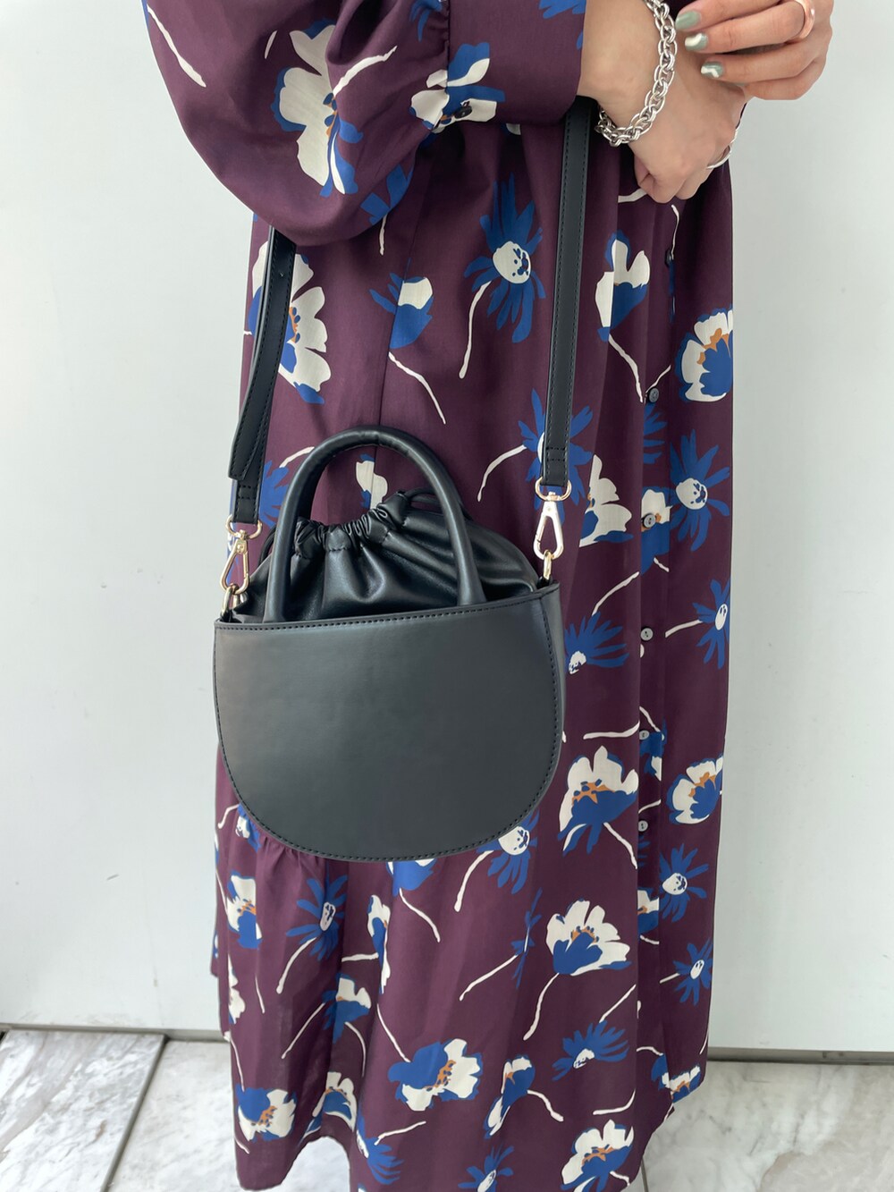 パープル系のワンピース、ブラック系のショルダーバッグ、ブラック系のブーツを着用したレディースの夏コーディネートの4枚目の写真