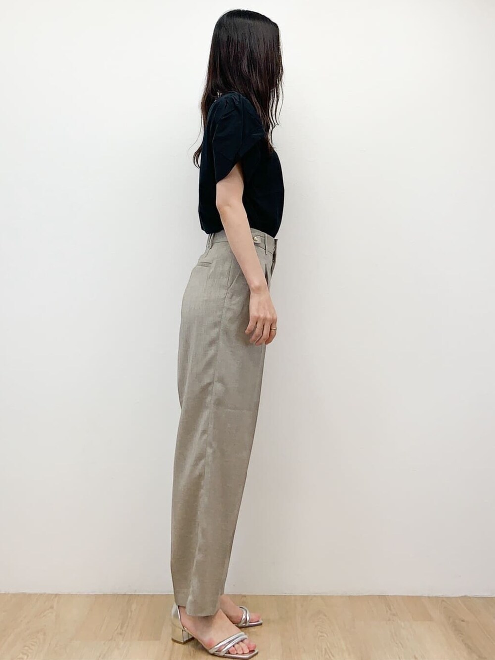 ブラック系のTシャツ/カットソー、ベージュ系のその他パンツ、シルバー系のサンダルを着用したレディースの春コーディネートの3枚目の写真