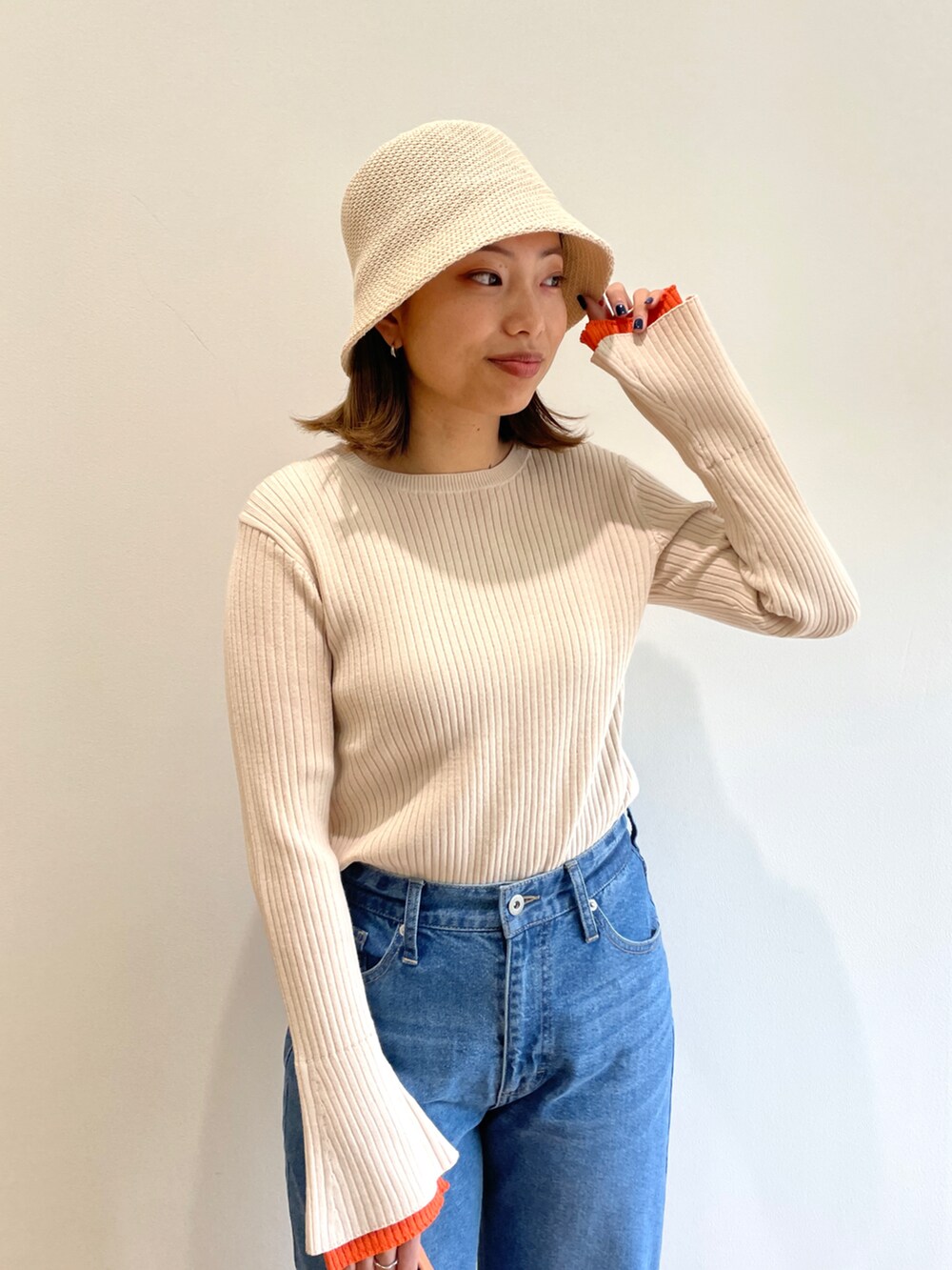 ベージュ系のニット/セーター、ブルー系のデニムパンツ、ホワイト系のその他シューズを着用したレディースの冬コーディネートの4枚目の写真