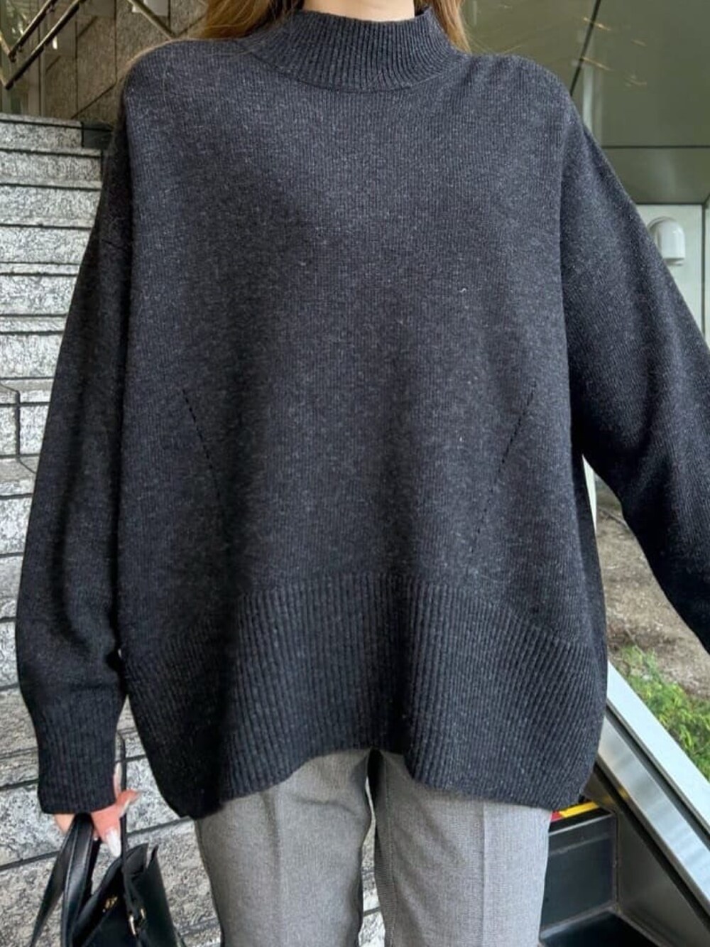 グレー系のニット/セーター、ブラック系のその他パンツ、ブラック系のトートバッグを着用したレディースの冬コーディネートの5枚目の写真