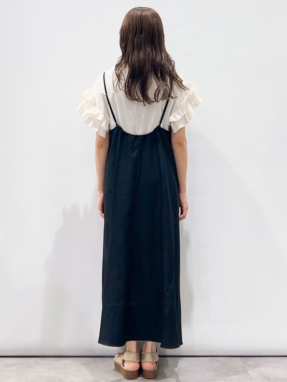 ブラック系のワンピース、ベージュ系のサンダル、ホワイト系のTシャツ/カットソーを着用したレディースの夏コーディネートの4枚目の写真