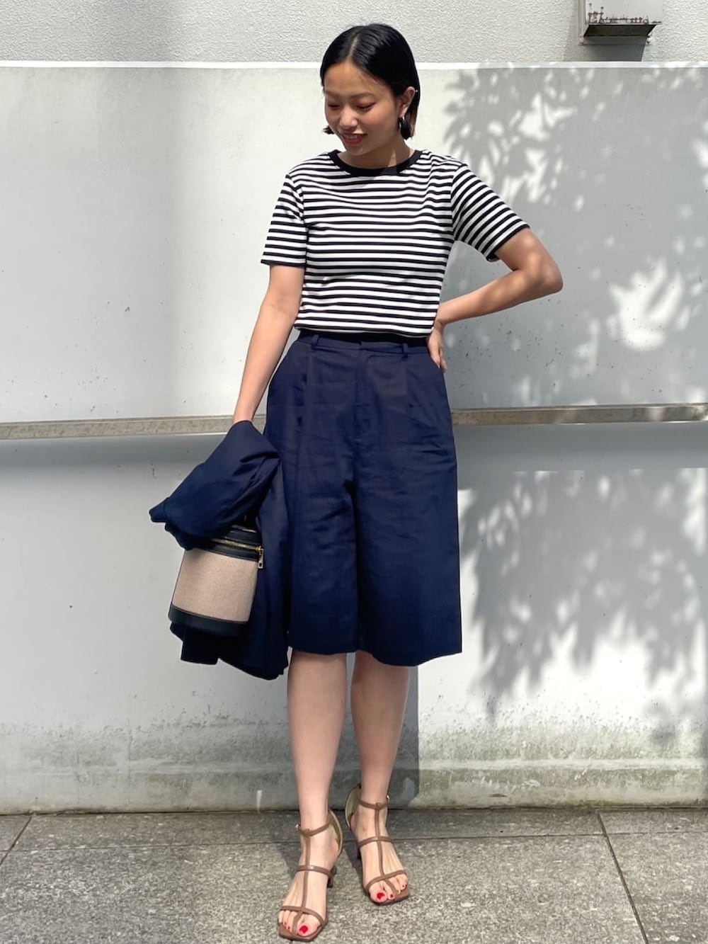 ブルー系のテーラードジャケット、ホワイト系のTシャツ/カットソー、ブラウン系のサンダルを着用したレディースの春コーディネートの4枚目の写真
