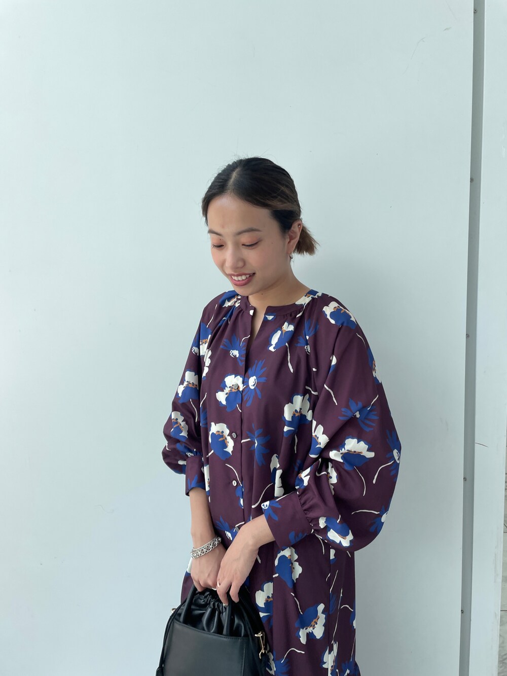 パープル系のワンピース、ブラック系のショルダーバッグ、ブラック系のブーツを着用したレディースの夏コーディネートの3枚目の写真