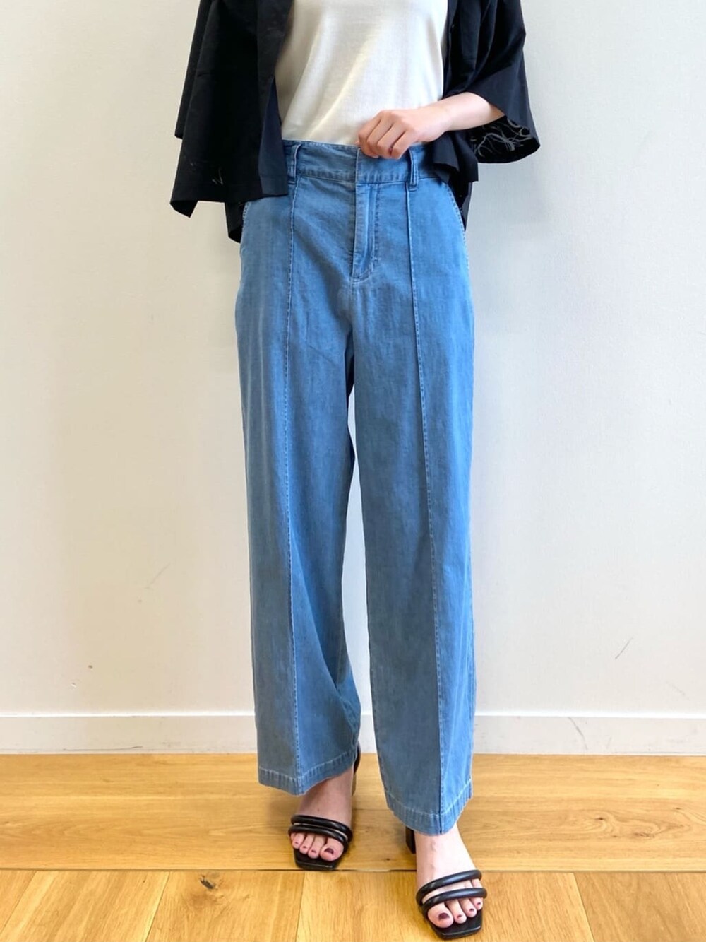 ブルー系のデニムパンツ、ブラック系のサンダル、ブラック系のシャツ/ブラウスを着用したレディースの夏コーディネートの7枚目の写真