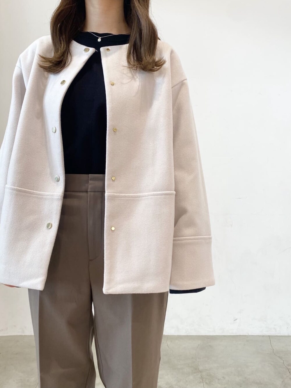 ブラウン系のその他パンツ、ベージュ系のノーカラーコート、ブラック系のニット/セーターを着用したレディースの秋コーディネートの3枚目の写真