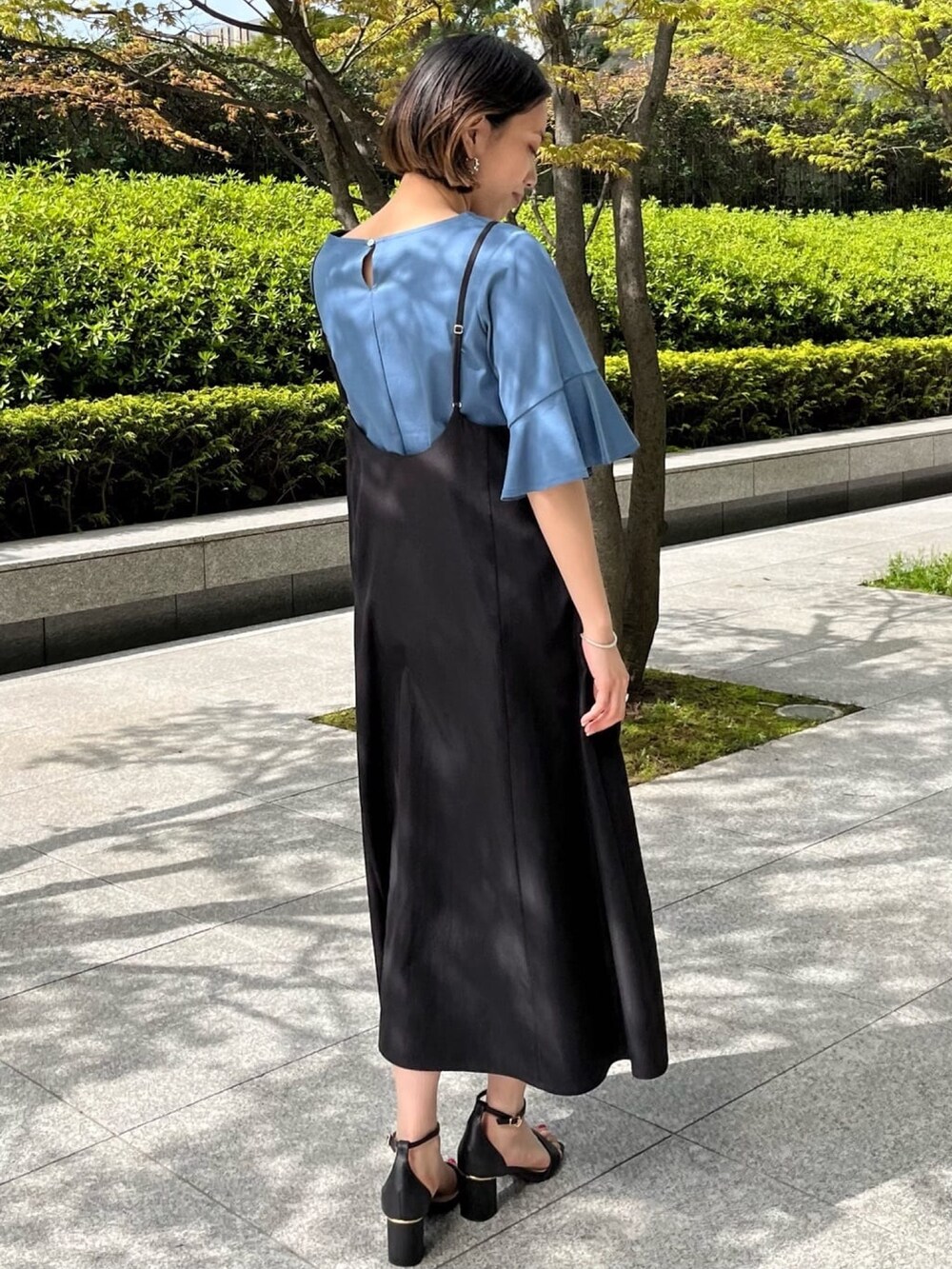 ブルー系のTシャツ/カットソー、ブラック系のワンピース、ブラック系のサンダルを着用したレディースの夏コーディネートの2枚目の写真