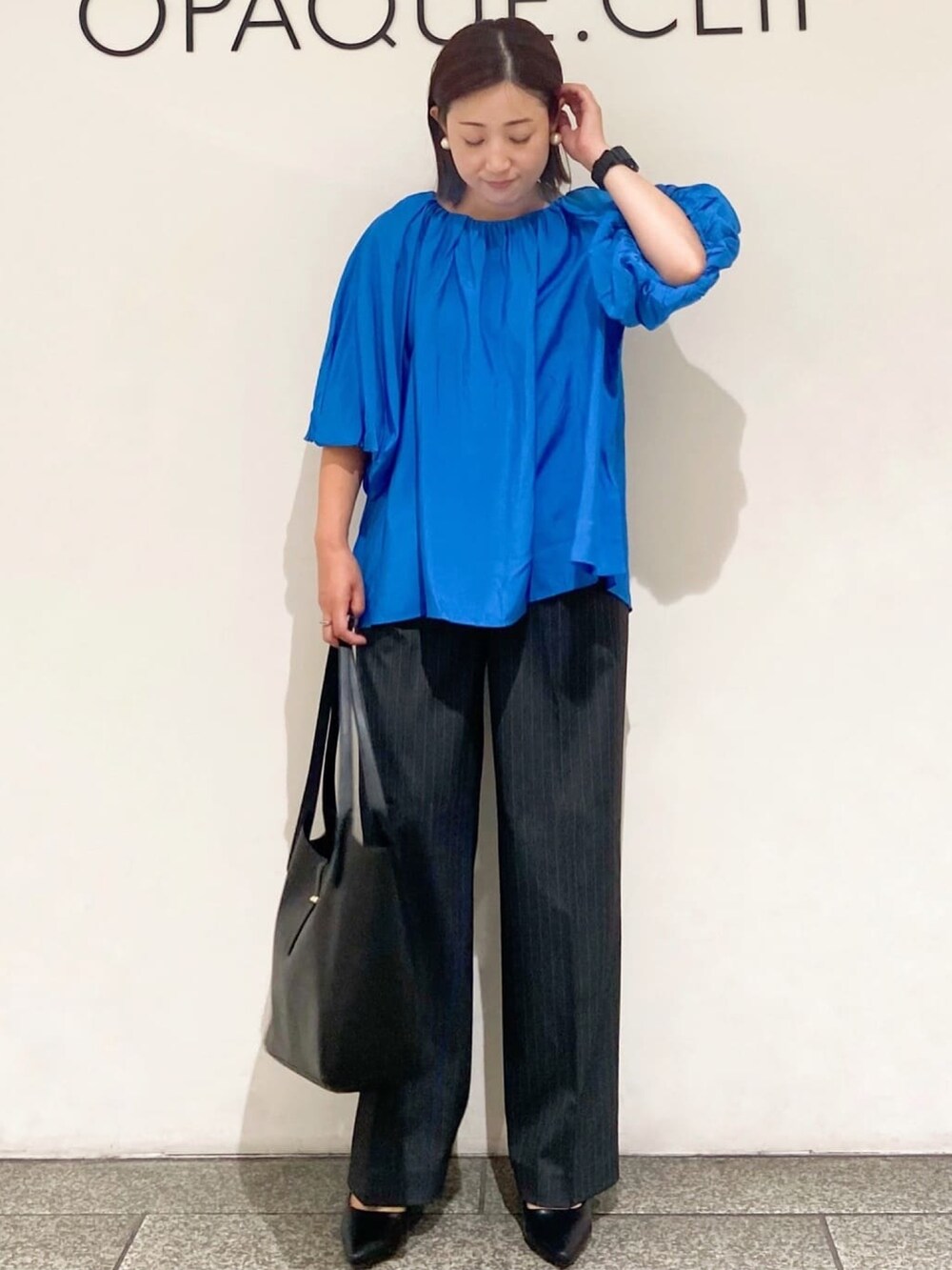 ブルー系のシャツ/ブラウス、グレー系のその他パンツ、ブラック系のトートバッグを着用したレディースの夏コーディネートの2枚目の写真