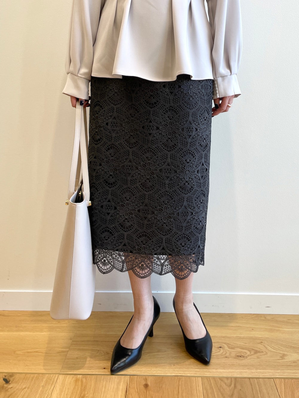 グレー系のシャツ/ブラウス、グレー系のスカート、ベージュ系のトートバッグを着用したレディースの冬コーディネートの5枚目の写真