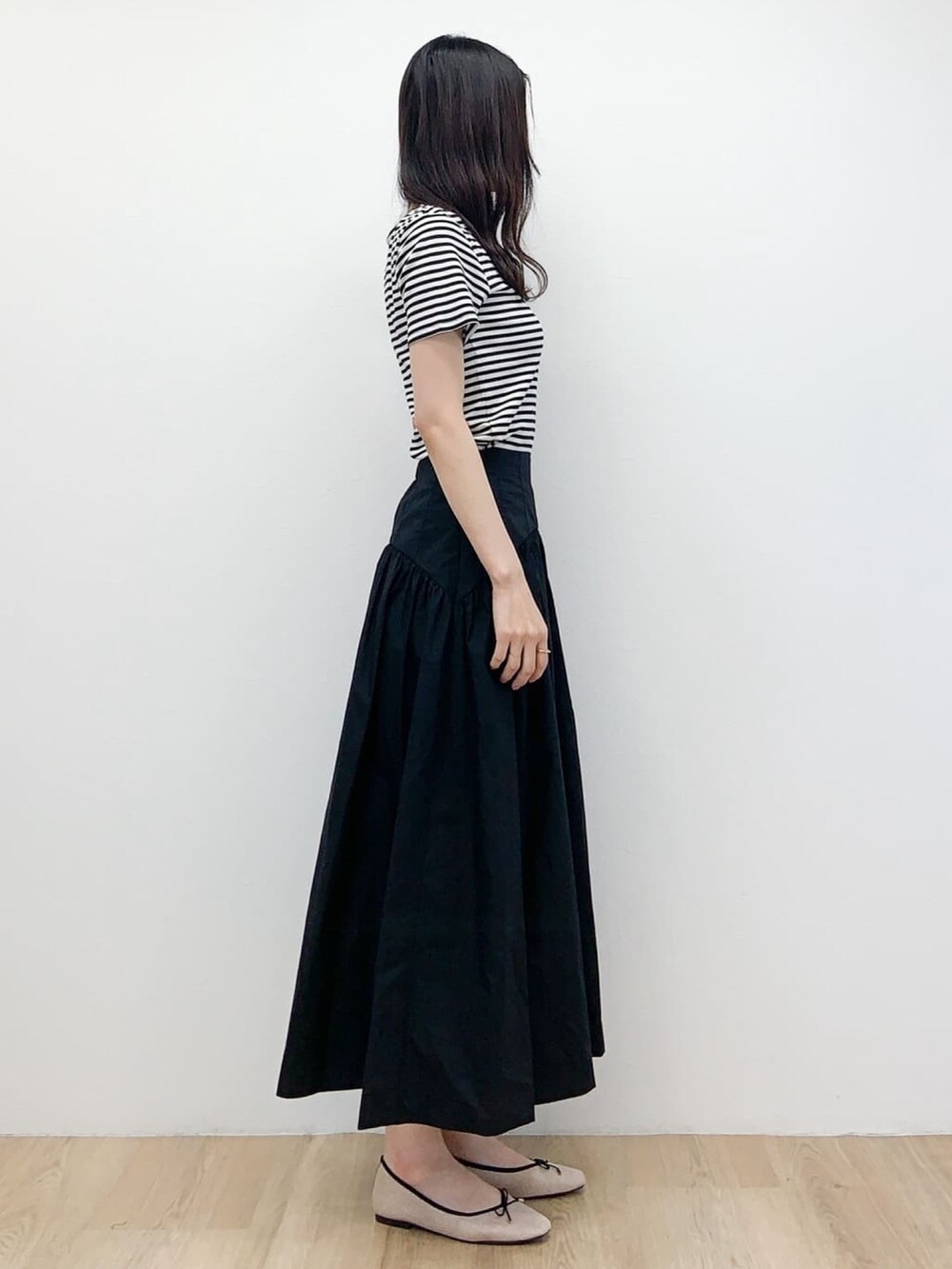 ピンク系のカーディガン/ボレロ、ブラック系のスカート、ベージュ系のその他シューズを着用したレディースの春コーディネートの6枚目の写真