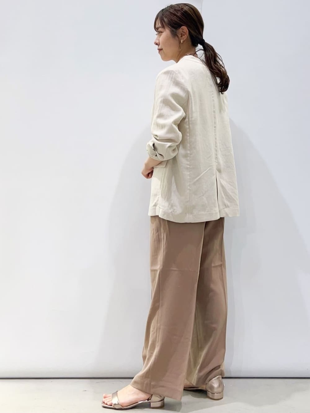 ゴールド系のサンダル、ホワイト系のニット/セーター、ベージュ系のその他パンツを着用したレディースの春コーディネートの2枚目の写真