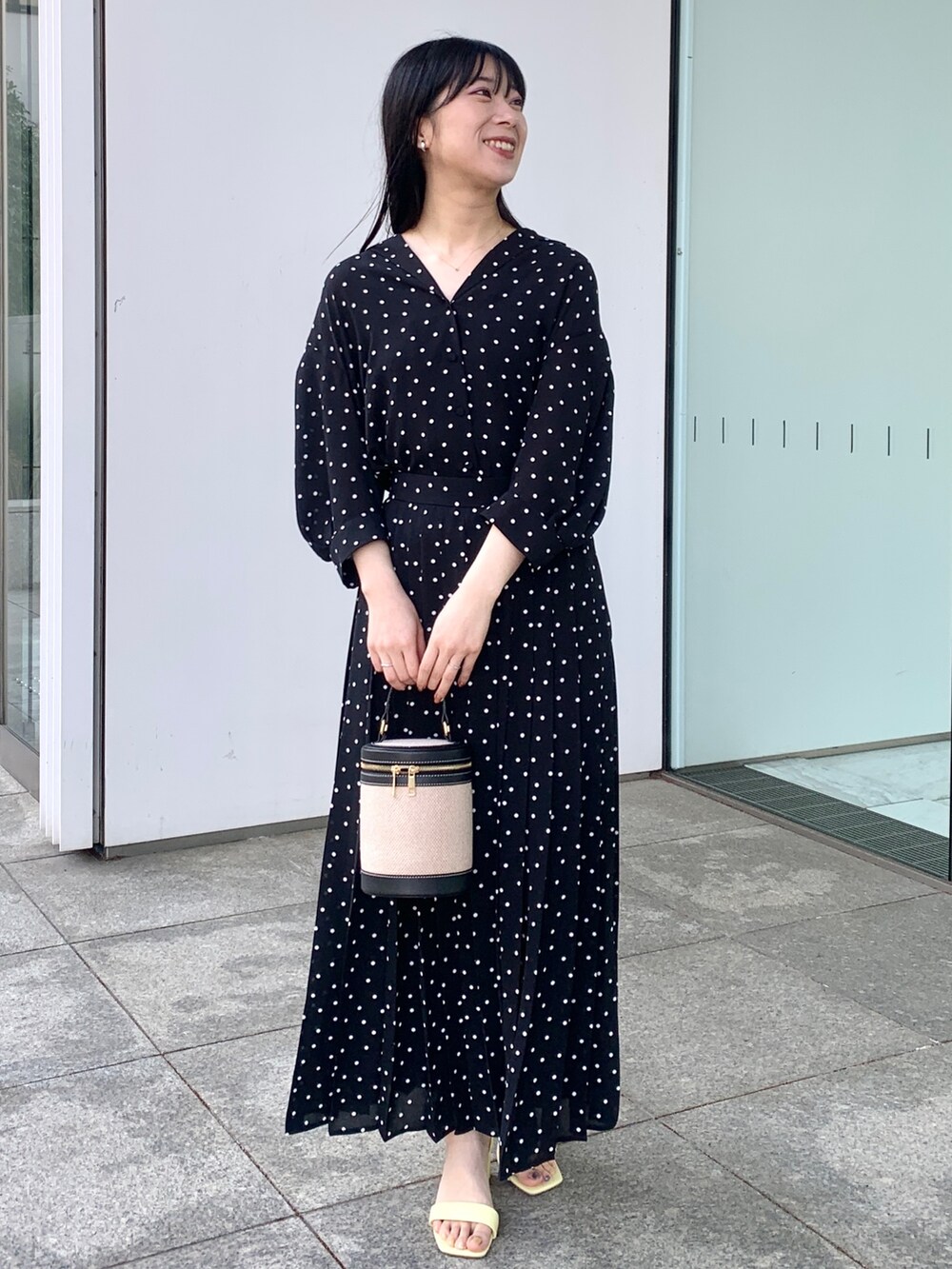 ブラック系のシャツ/ブラウス、ブラック系のスカート、ブラック系のショルダーバッグを着用したレディースの春コーディネートの2枚目の写真