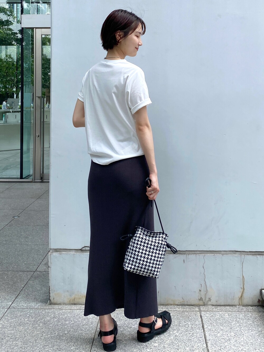 ホワイト系のTシャツ/カットソー、グレー系のスカート、ブラック系のショルダーバッグを着用したレディースの夏コーディネートの3枚目の写真