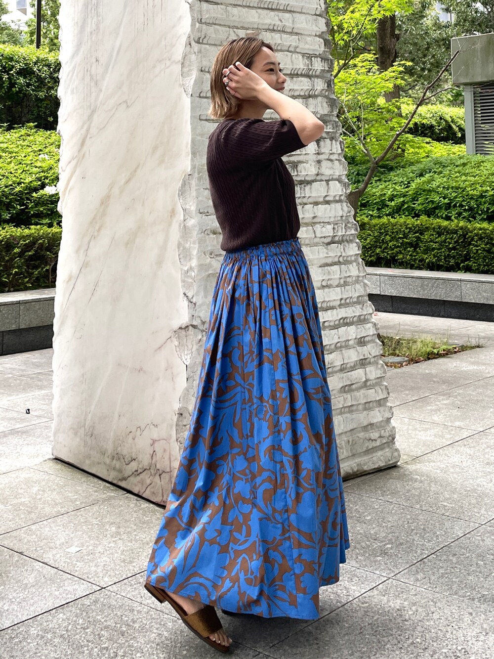 ブラウン系のニット/セーター、ブラウン系のスカート、その他のサンダルを着用したレディースの夏コーディネートの2枚目の写真