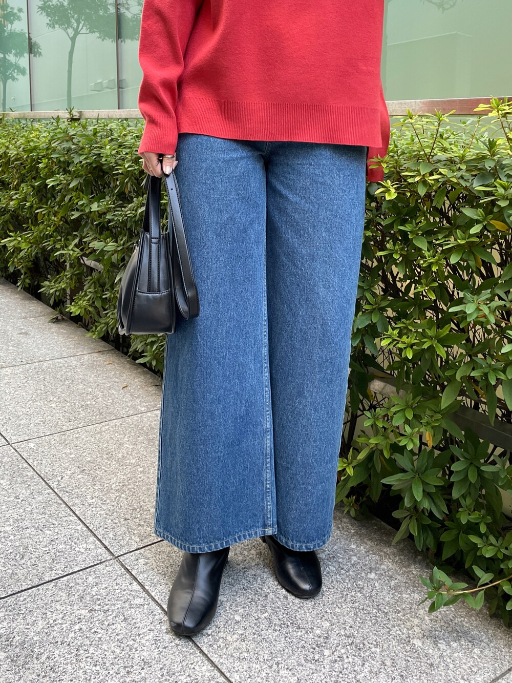 レッド系のニット/セーター、ブルー系のその他パンツ、ブラック系のブーツを着用したレディースの冬コーディネートの5枚目の写真