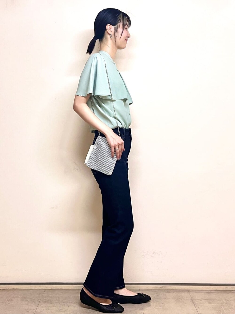 グリーン系のシャツ/ブラウス、ブラック系のパンプス、ブルー系のデニムパンツを着用したレディースの夏コーディネートの3枚目の写真