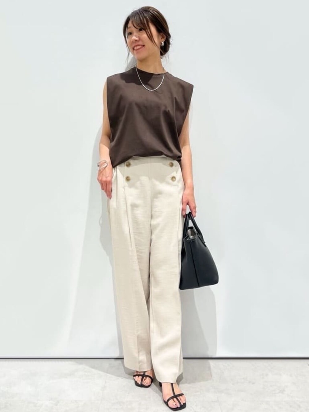 ベージュ系のその他パンツ、ブラック系のトートバッグ、ブラック系のサンダルを着用したレディースの夏コーディネートの4枚目の写真