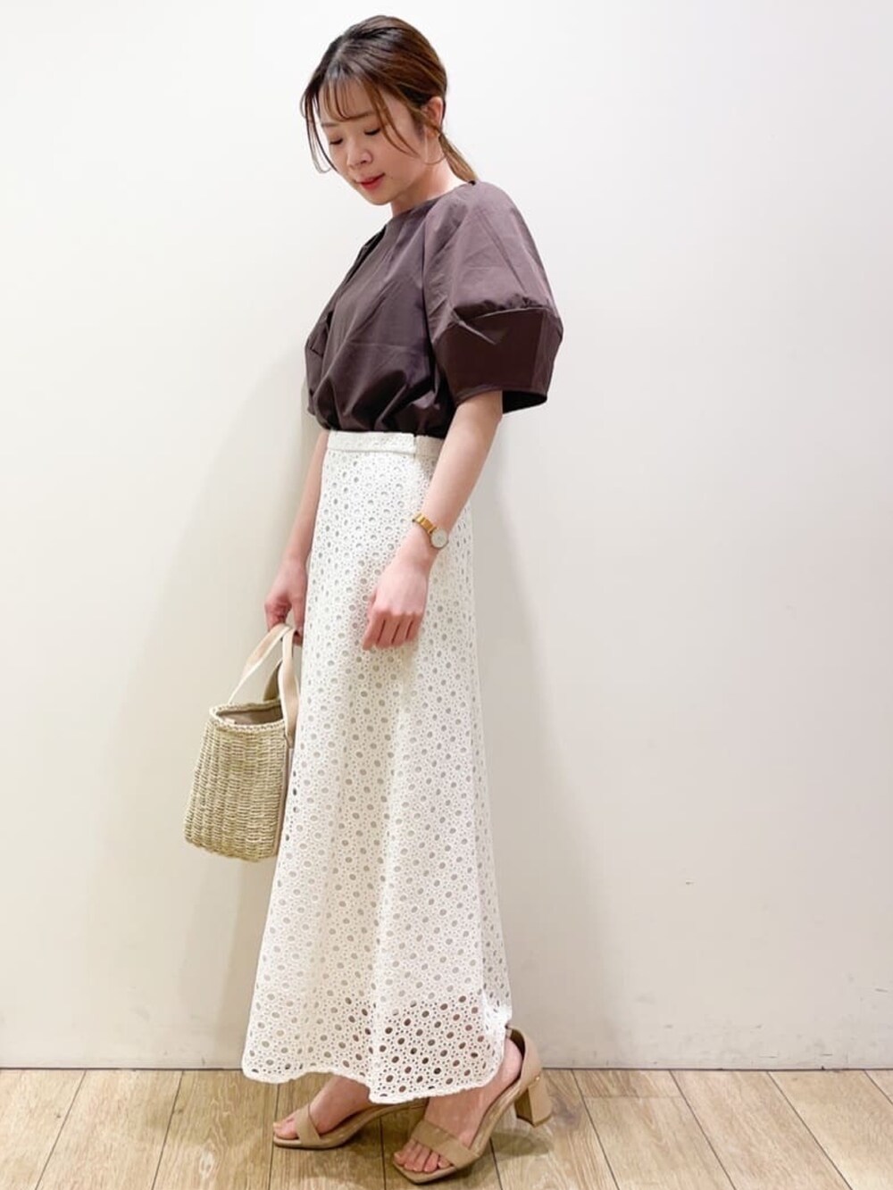 ブラウン系のTシャツ/カットソー、ホワイト系のスカート、ベージュ系のトートバッグを着用したレディースの春コーディネートの2枚目の写真